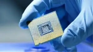 Close-up Presentation of a New Generation Microchip. Gloved Hand Holding Piece of Technological Wonder. Semiconductor stocks are in the news.