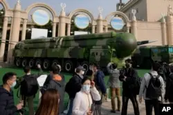 At the Beijing Exhibition Hall in Beijing on October 12, 2022, guests can take a tour of defense lorries carrying the Dong Feng 41 and DF- 17 nuclear weapons. ( AP Photo/Andy Wong )