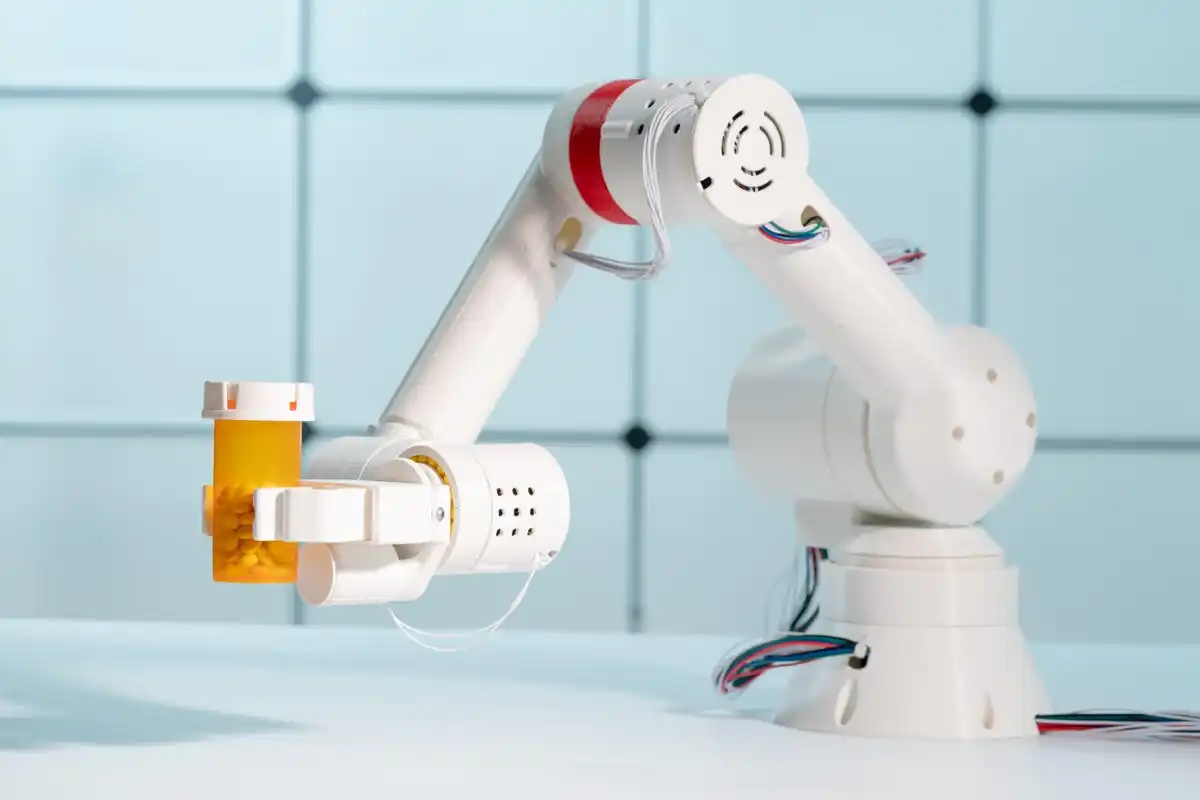 A robotic arm holding a pill bottle of medication