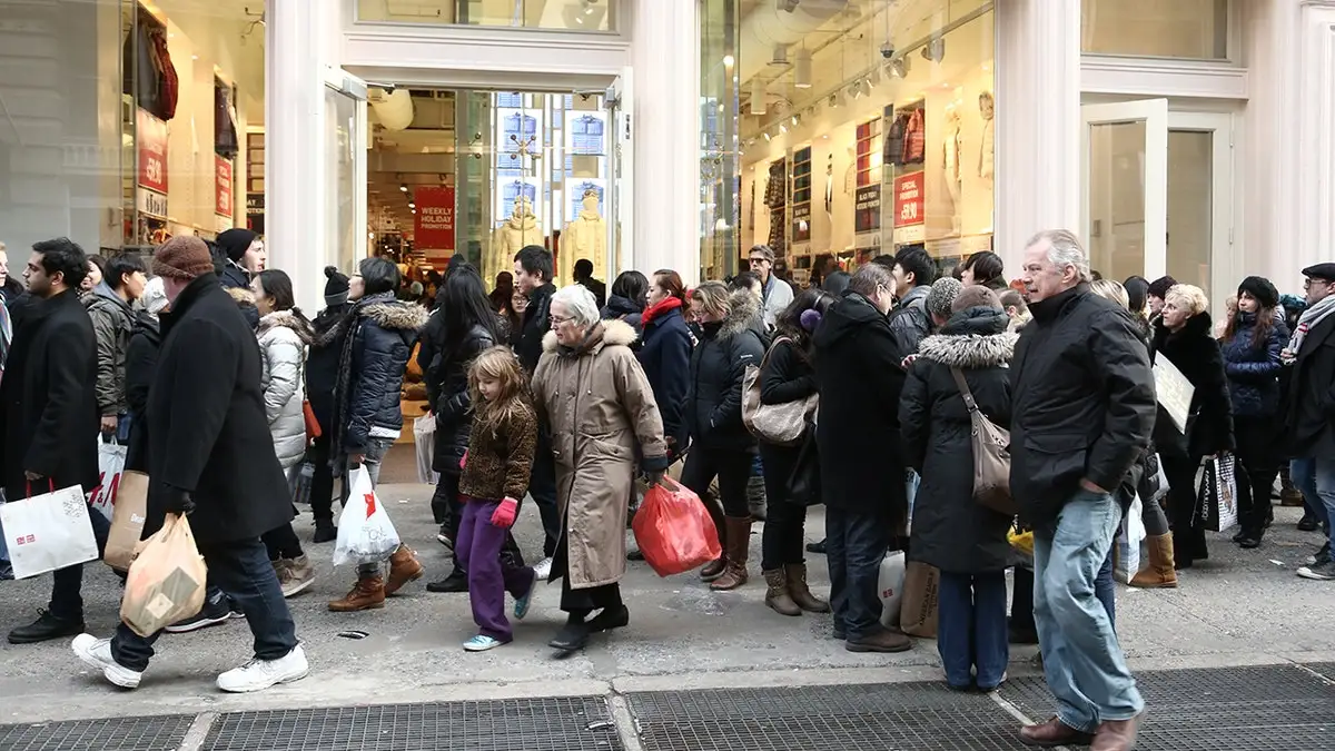 people walking to stores with shopping bags