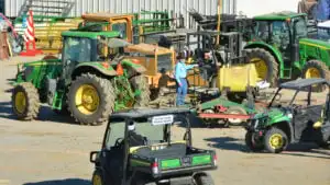 Several John Deere vehicles are parked outside of a building.